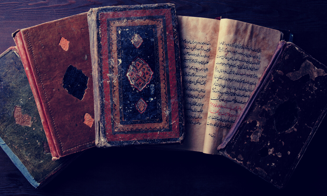 Stack of open ancient books in Arabic. Old Arabic manuscript