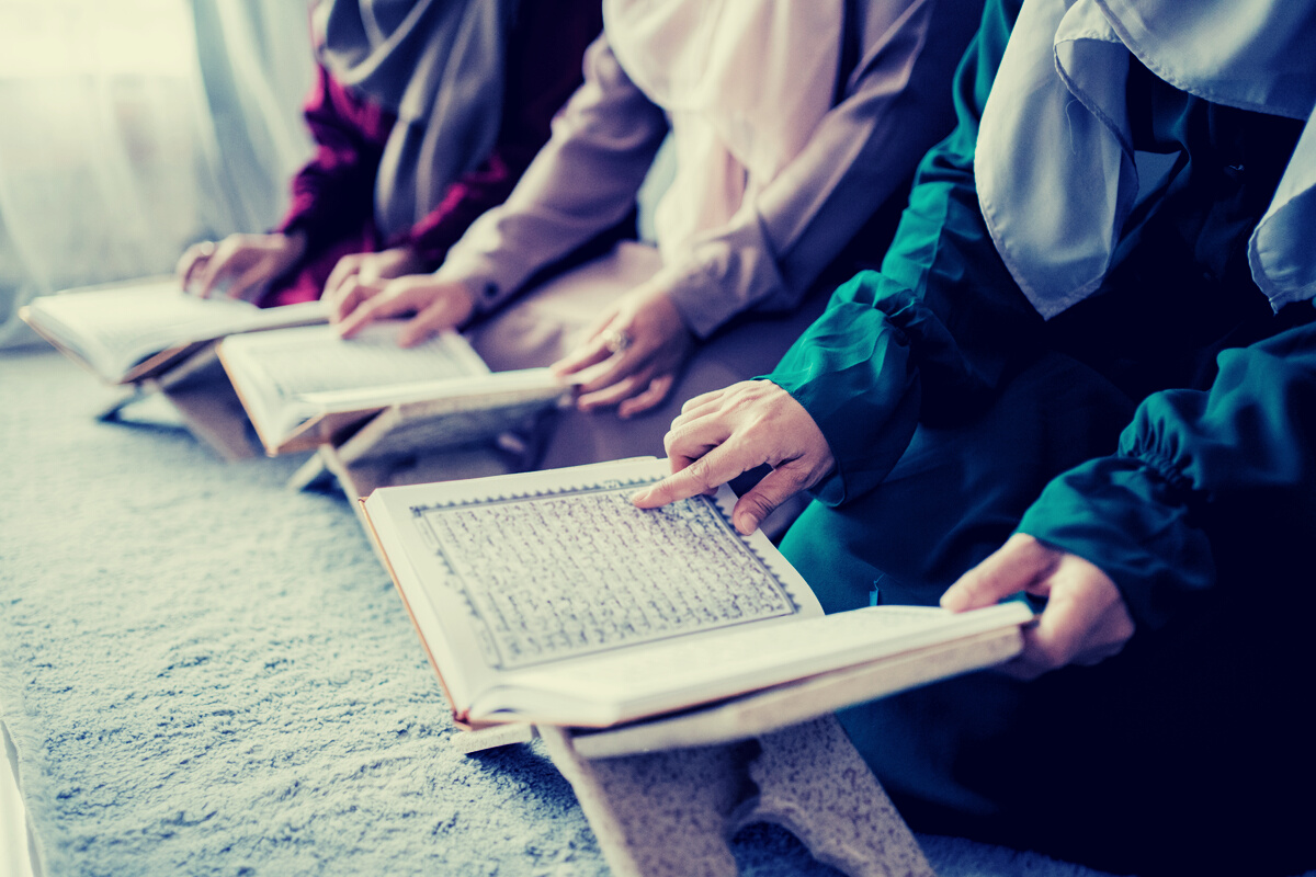 Three Young Women Wearing Hijabs Read the Holy Book of the Al-Quran Together